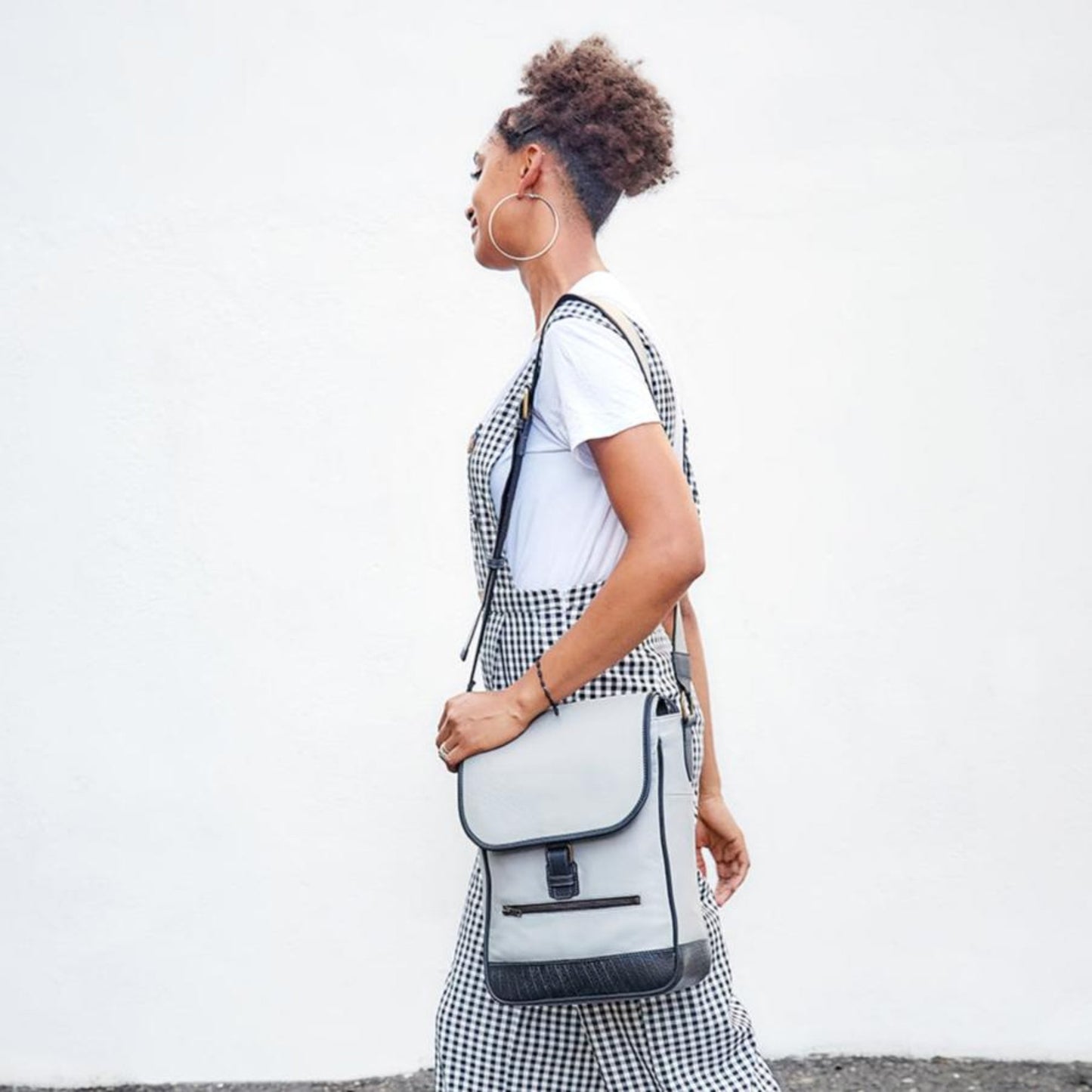 model carrying The Miina Hudson messenger hand bag in grey and black