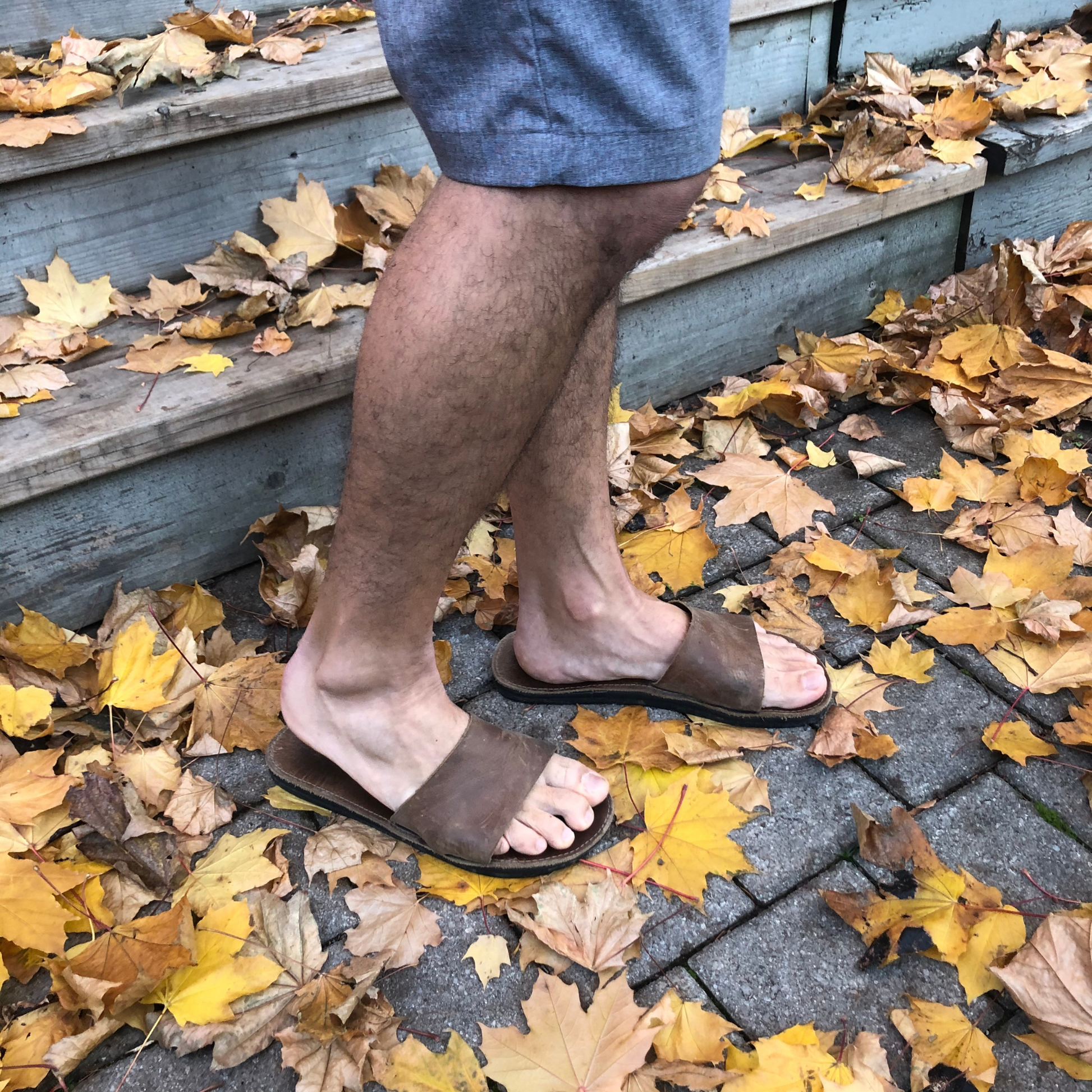 wearing the Miina Antonio Leather Slide Sandal in Cocoa surrounded by autumn leaves
