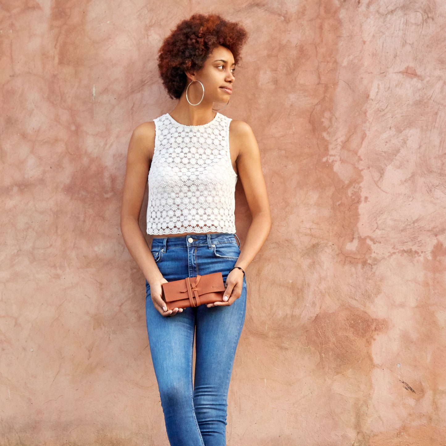 A woman holding the Miina Sandra Leather Pouch, emphasizing its elegant, compact design and versatile style