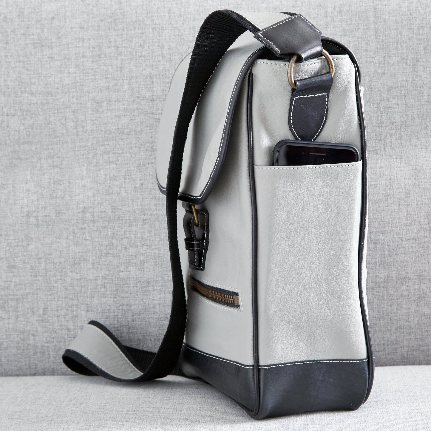 Side view of The Miina Hudson messenger bag made with grey upcycled aircraft leather