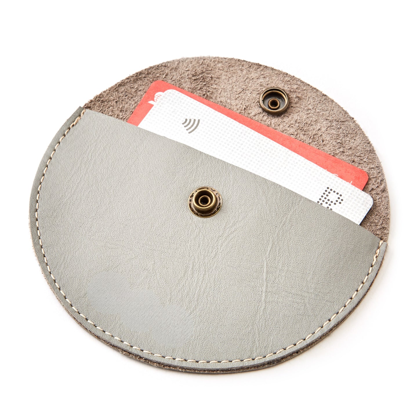 The Miina Medio Half-moon gray coin purse crafted with sustainably sourced materials, featuring a sleek and minimalist design with a curved silhouette. Perfect for carrying coins and small essentials while promoting eco-conscious living.